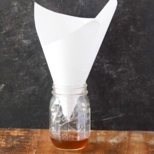 DIY Fruit Fly Trap - a jar with apple cider vinegar, soap and a cone funnel on top.