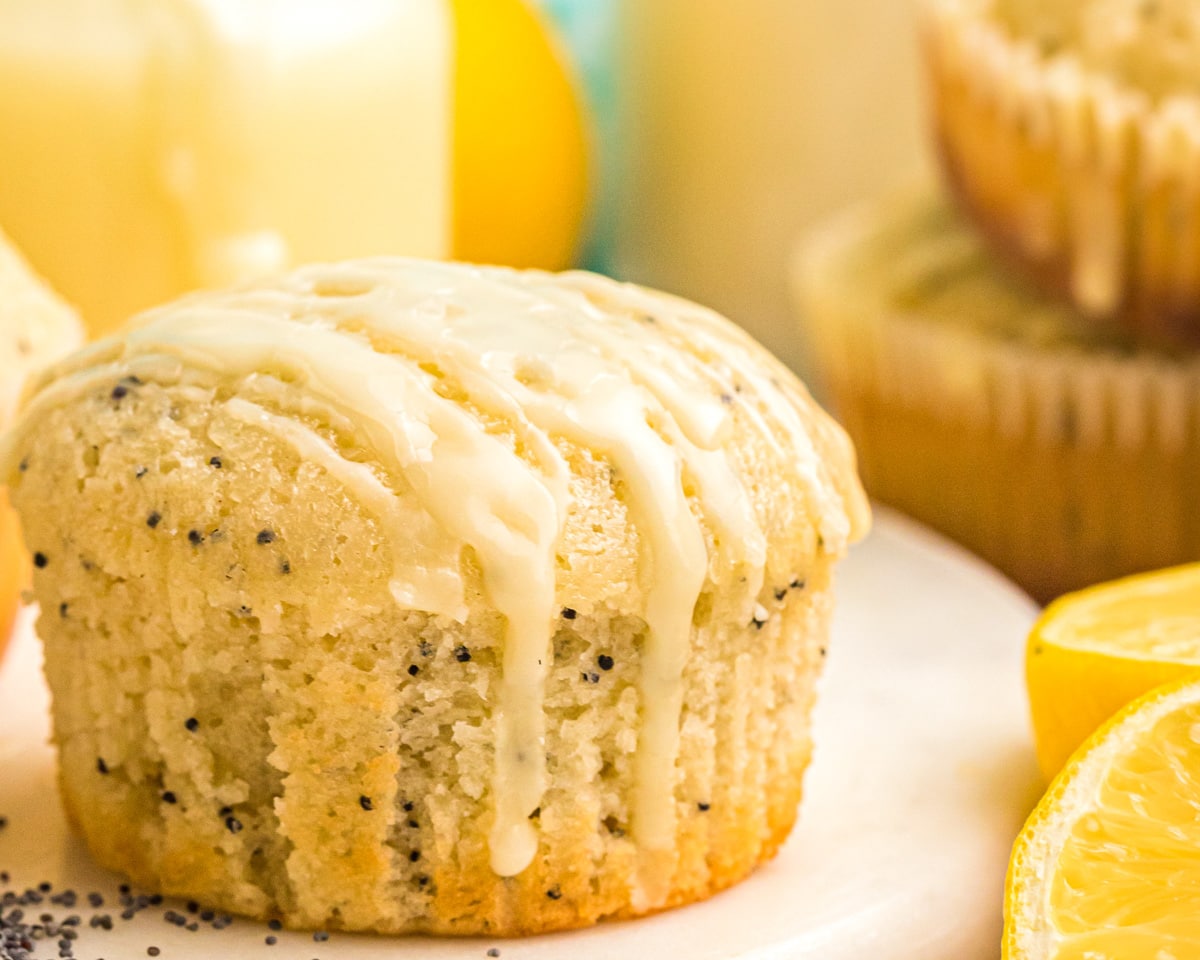 Close up image of Lemon Poppyseed muffins with glaze drizzling down.