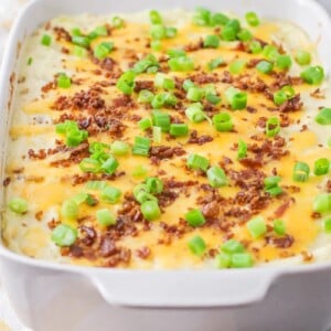 A mashed potato casserole topped with cheese and green onion.