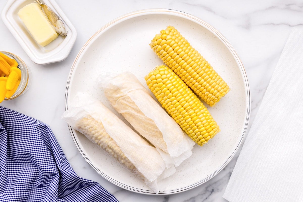 Wrapping cobs of corn in wet paper towels.