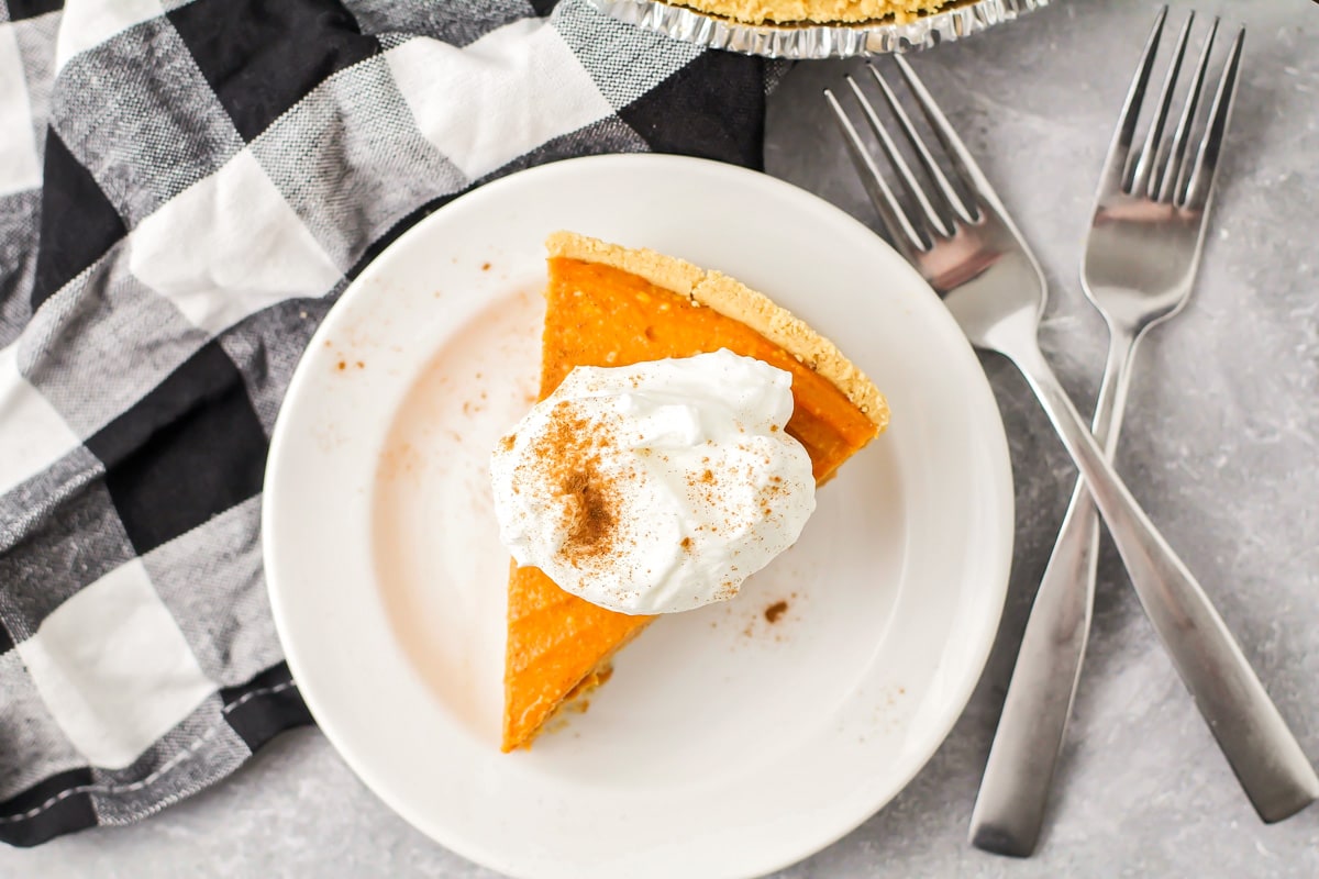 A slice of no bake pumpkin pie topped with cool whip.