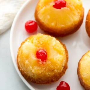 Top view of pineapple upside down cupcakes topped with pineapple and a cherry.