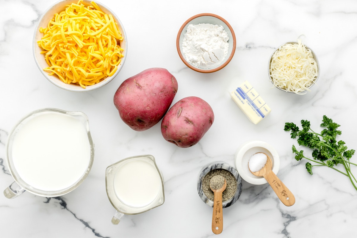Potatoes, cheese, flour, and other ingredients on a kitchen counter.