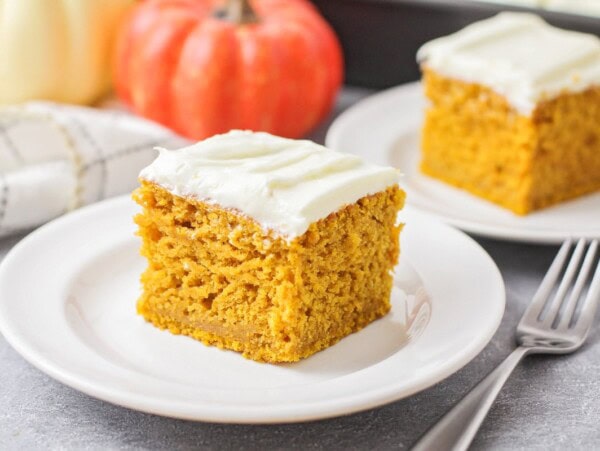 Slice of pumpkin cake on a white plate.