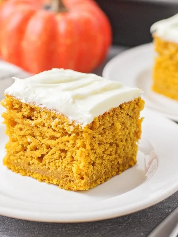 Slice of pumpkin cake on a white plate.