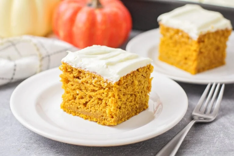 Slice of pumpkin cake on a white plate.