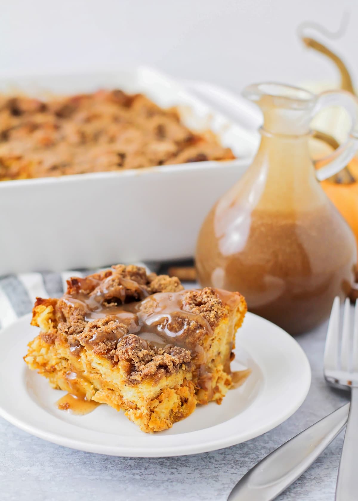 A slice of cinnamon french toast casserole covered with cinnamon buttermilk syrup.