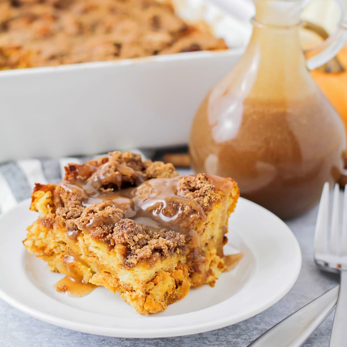 A slice of pumpkin french toast casserole topped with cinnamon buttermilk syrup.
