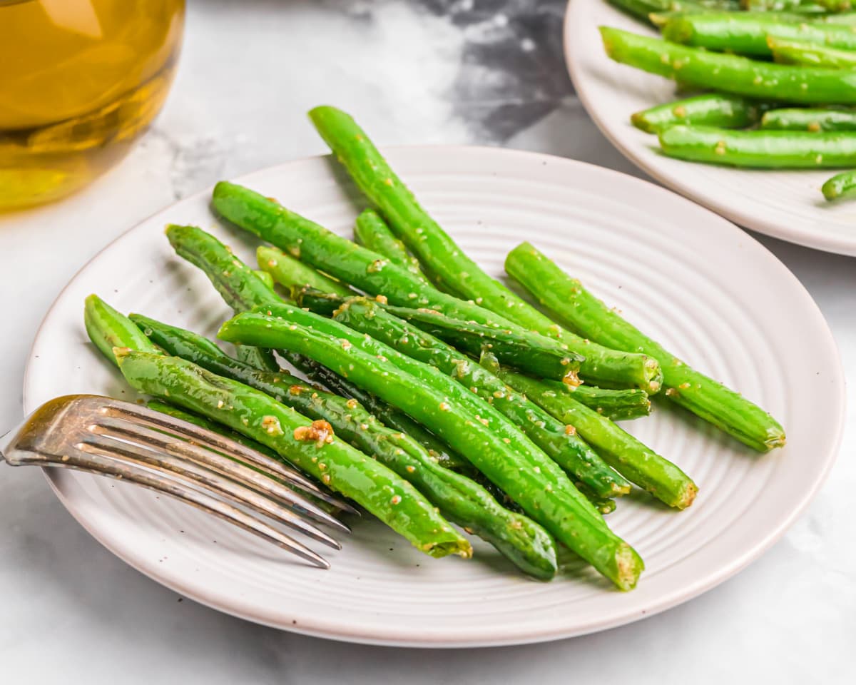 A plate of sauteed green beans seasoned with garlic.