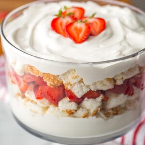 Strawberry shortcake trifle recipe in trifle dish with strawberries on top.
