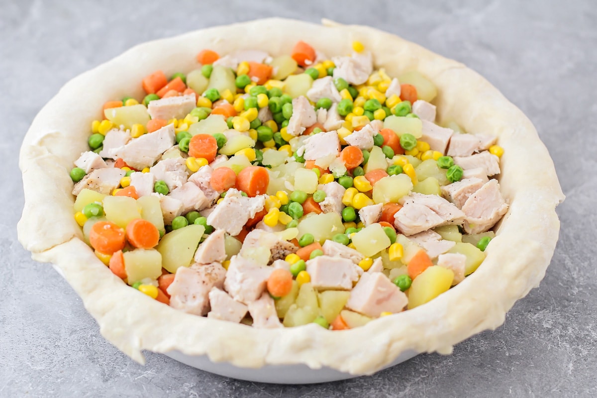 A crust filled with veggies, potatoes, and turkey.