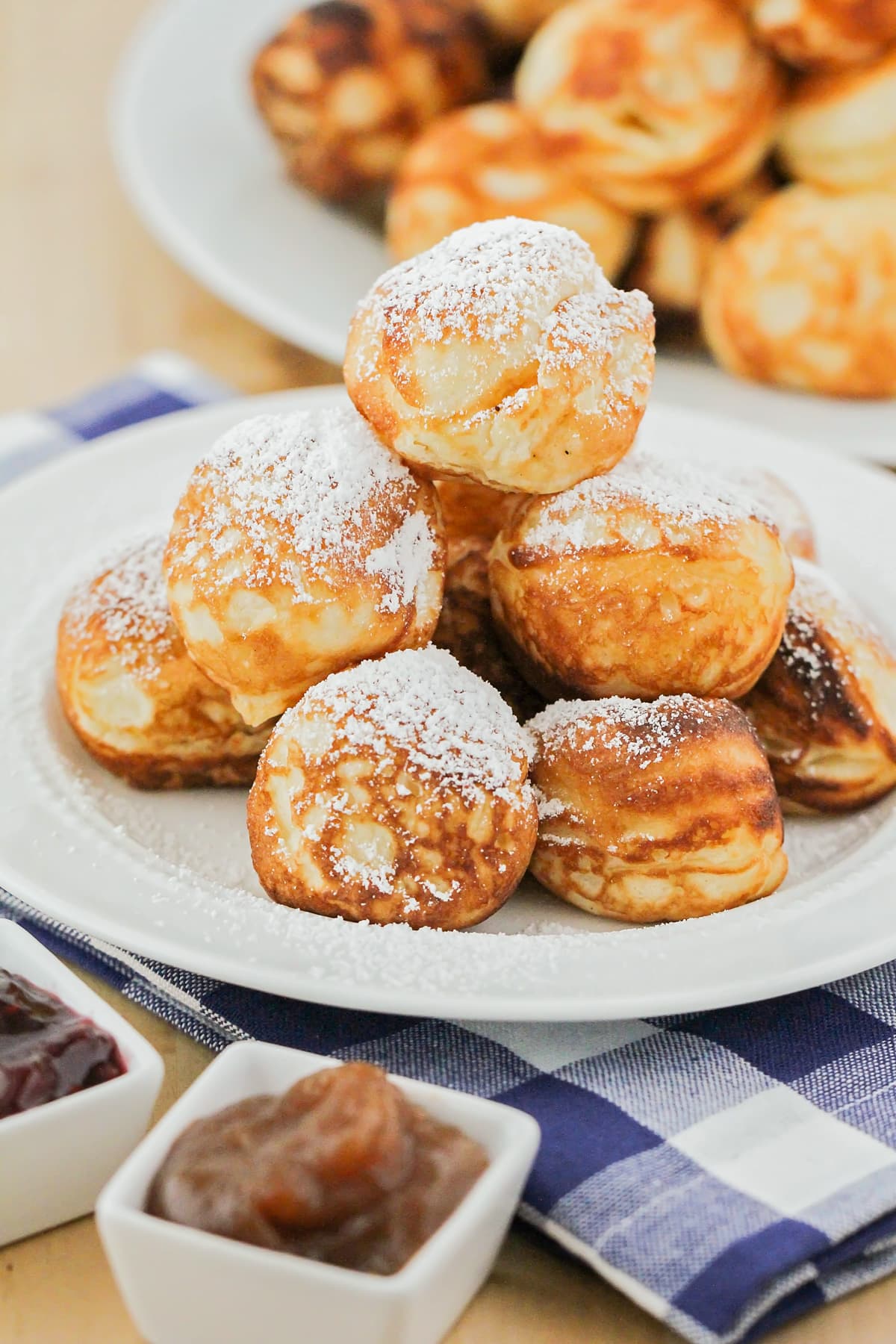 A pile of Aebleskiver dusted with powdered sugar.
