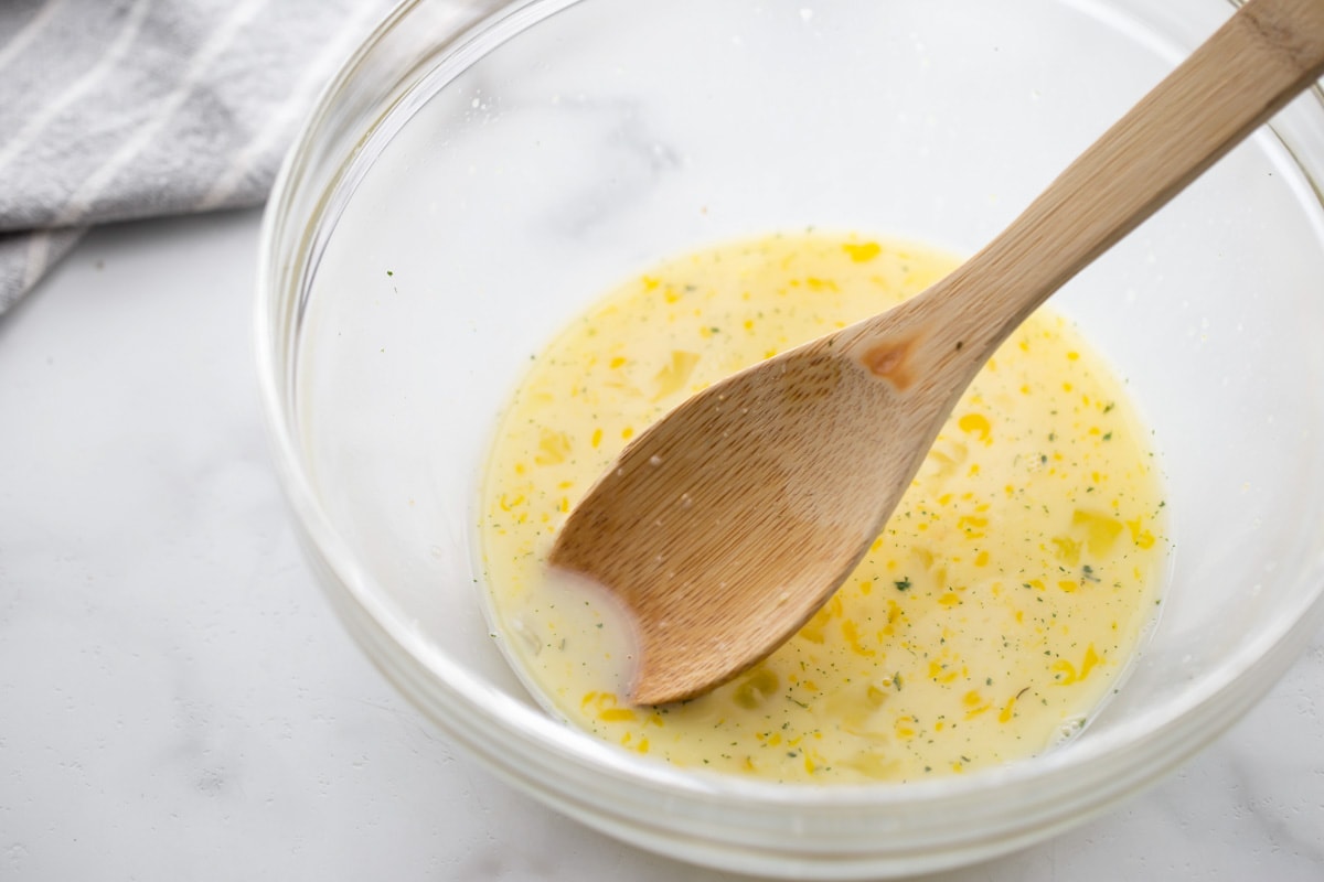 Egg, milk and garlic salt mixed together in a bowl.