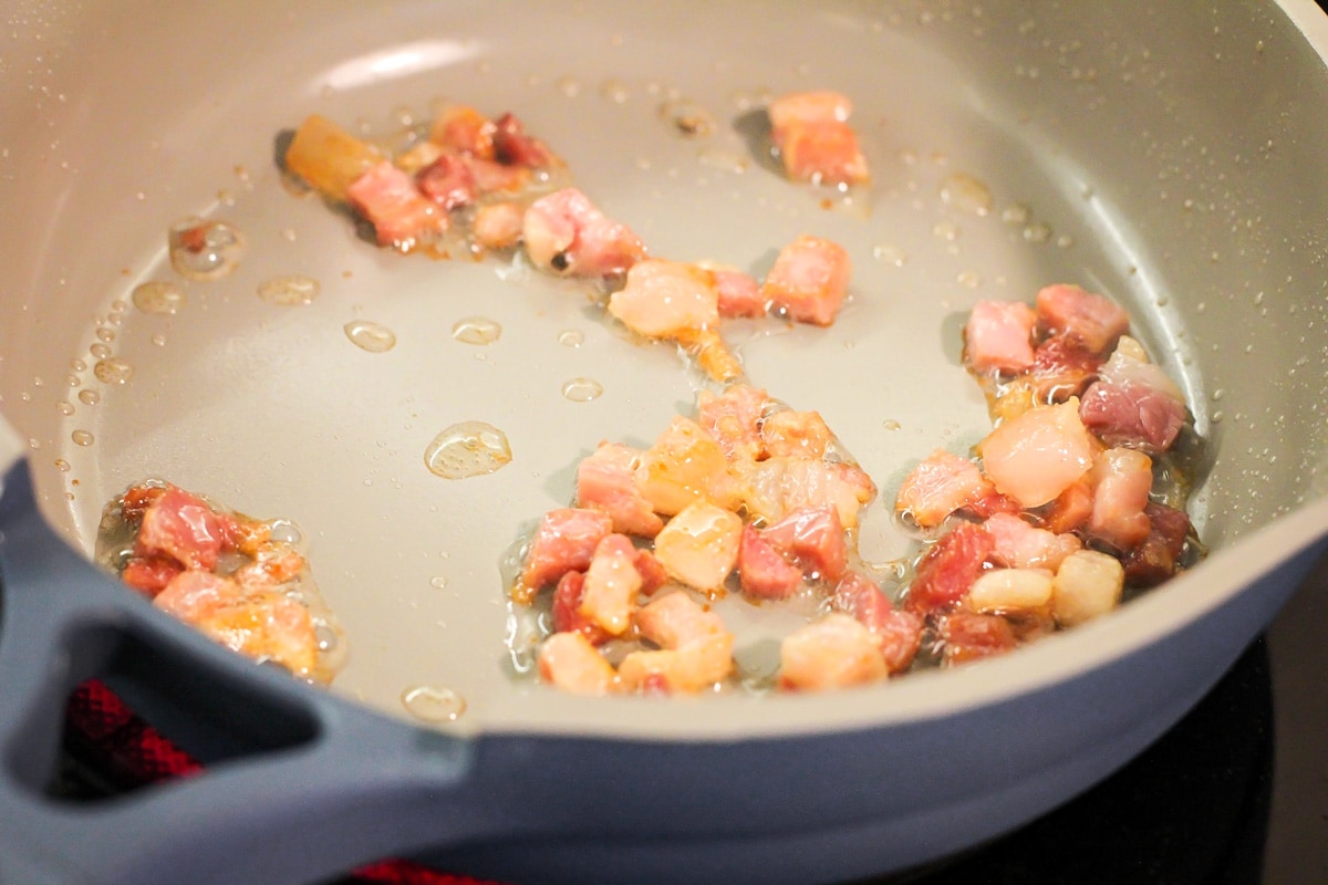 Crispy prosciutto in a pan on the stove.