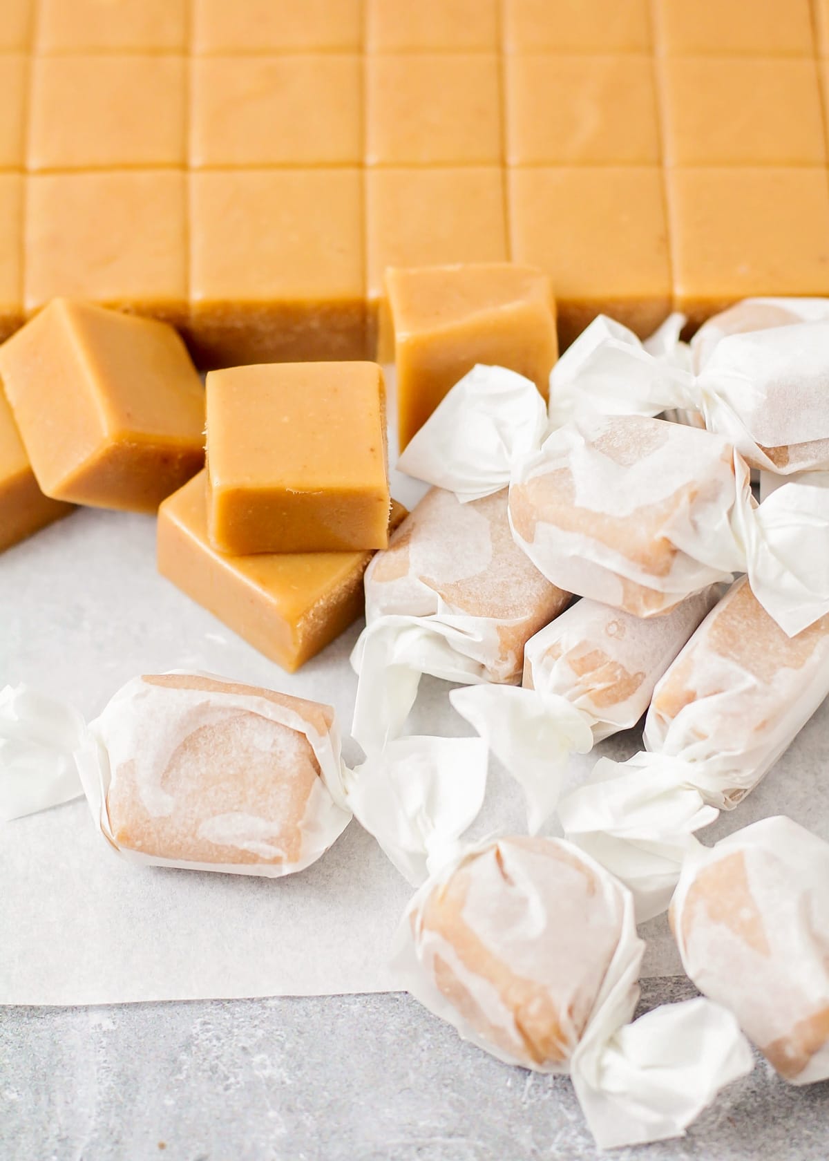 Homemade caramels cut and wrapped in wax paper.