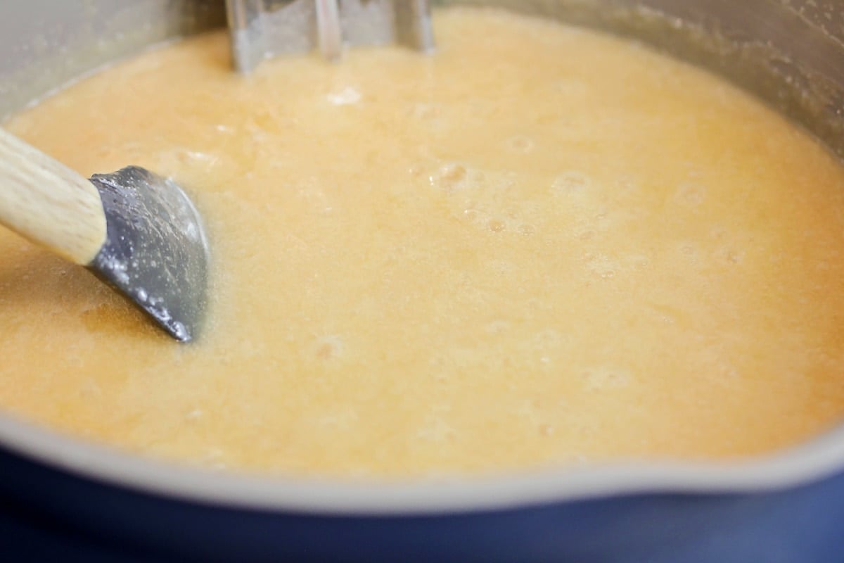 Butter and sugar mixture thickening in a pot.