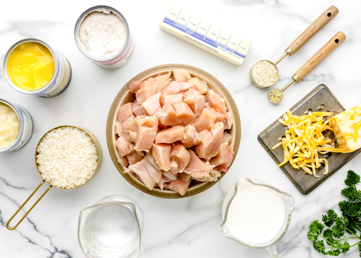 All of the ingredients needed for chicken and rice casserole laid out on a white countertop.