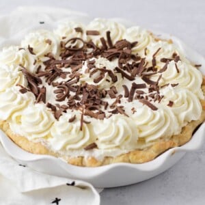 Chocolate cream pie recipe topped with whipped cream and chocolate curls.