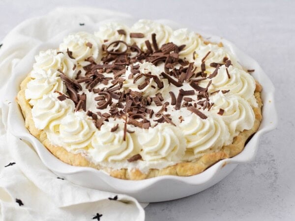 Chocolate cream pie recipe topped with whipped cream and chocolate curls.