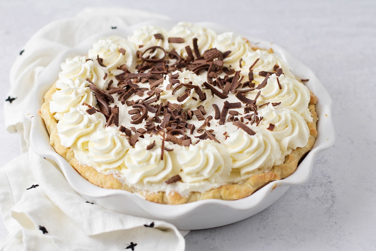 Chocolate cream pie topped with whipped cream and chocolate curls.