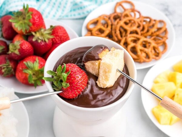 Chocolate fondue with strawberry and pound cake dipped into it.