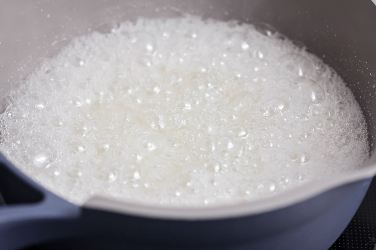 Sugar bubbling in a pot on the stove.