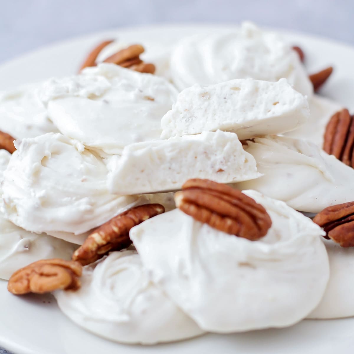 A plate filled with divinity recipe and pecans.