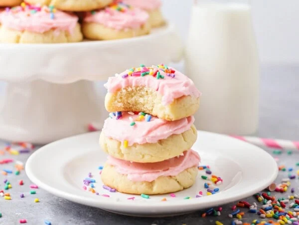 Three Drop sugar cookies stacked on top of each other with a bite taken out of the top cookie.