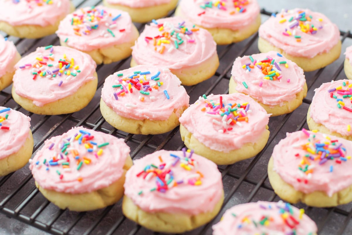 Pink frosted cookies on a wire rack.