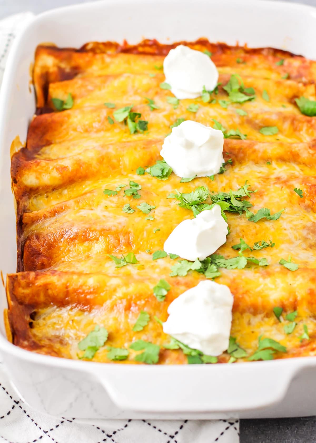 Close up of a baking dish filled with ground beef enchiladas.