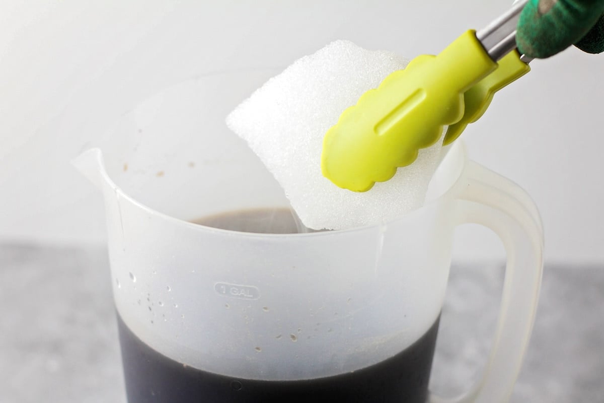 Adding dry ice to a root beer mixture.