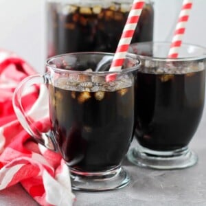 Two glassed of homemade root beer with straws.