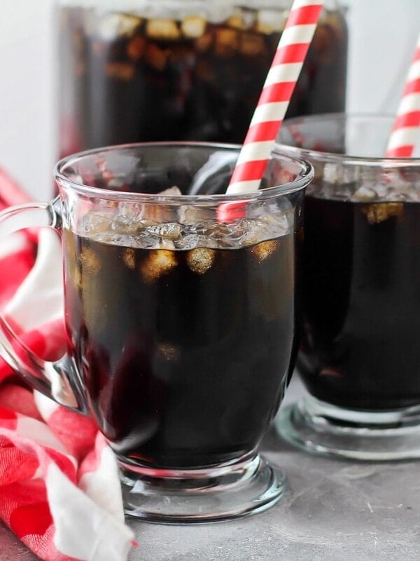 Two glassed of homemade root beer with straws.