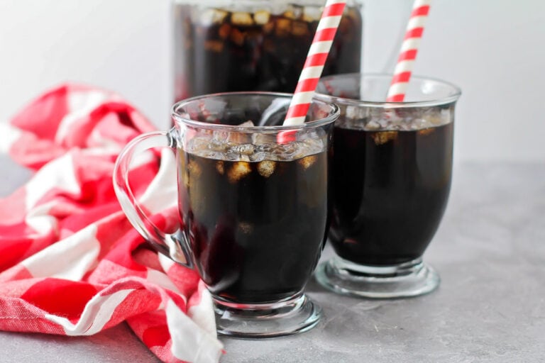 Two glassed of homemade root beer with straws.
