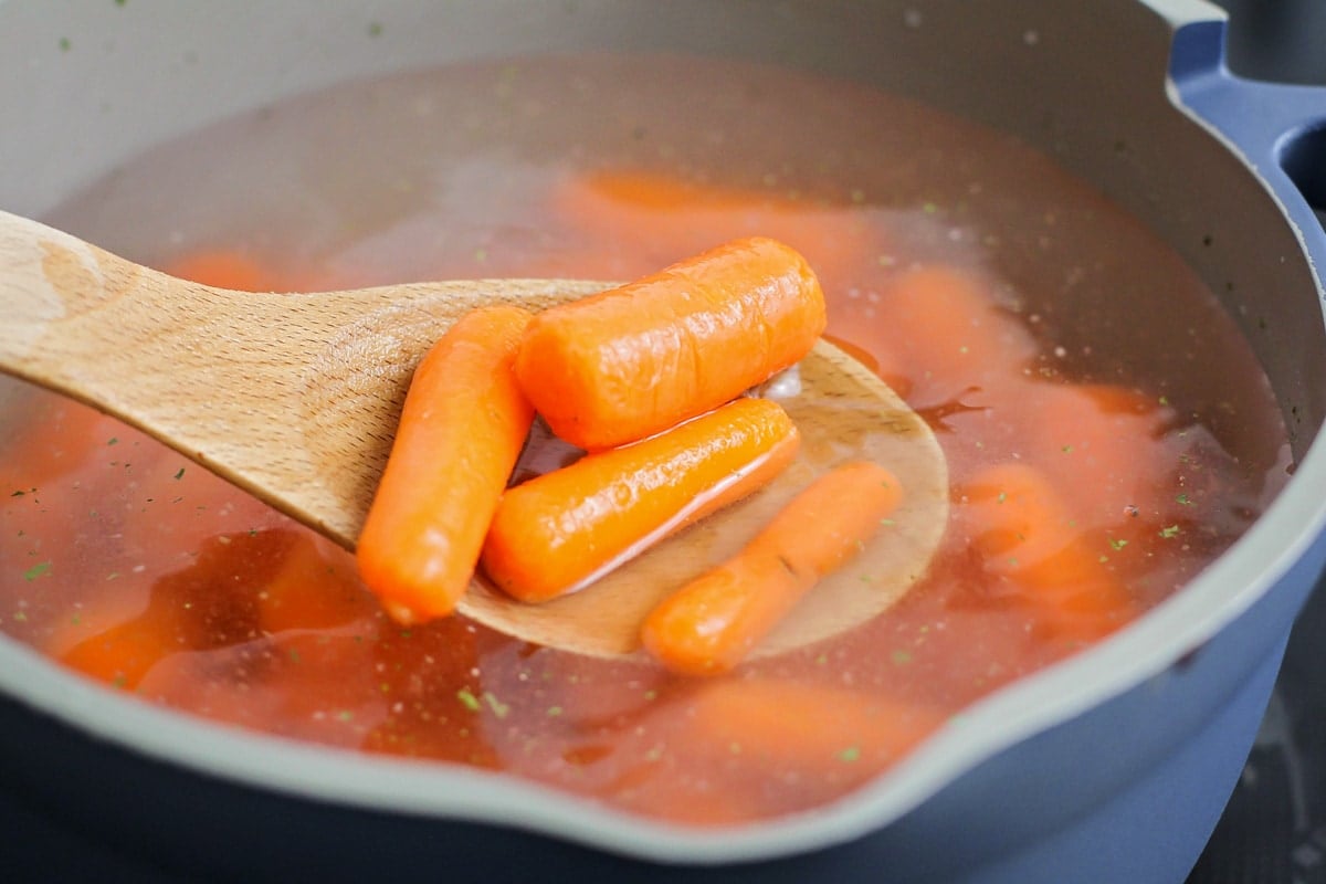 Cooking carrots in a pot of water on the stove.