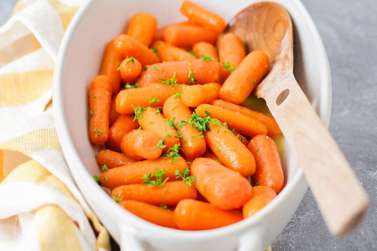 Honey glazed carrots in a white serving dish.
