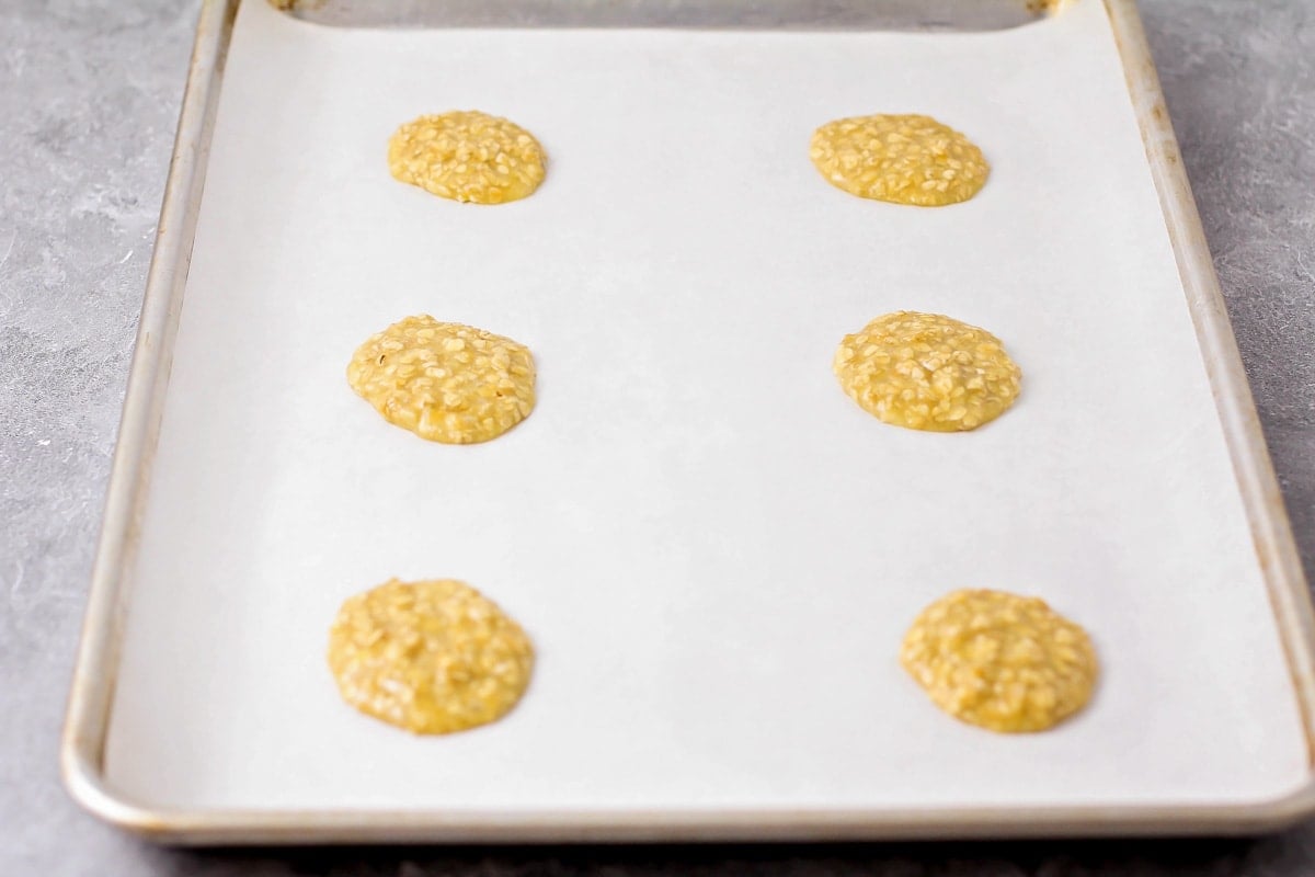 Oatmeal batter poured into cookie shape on a baking sheet.