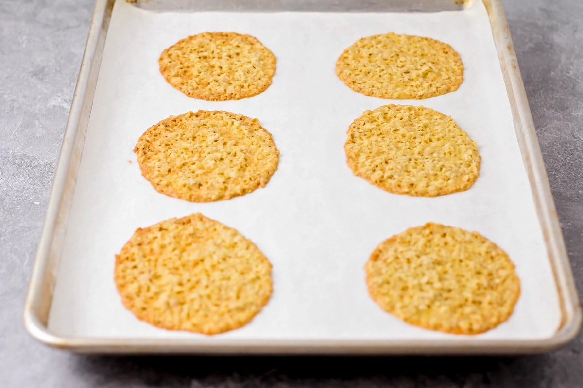 Spread lace cookies baked on a cookie sheet.