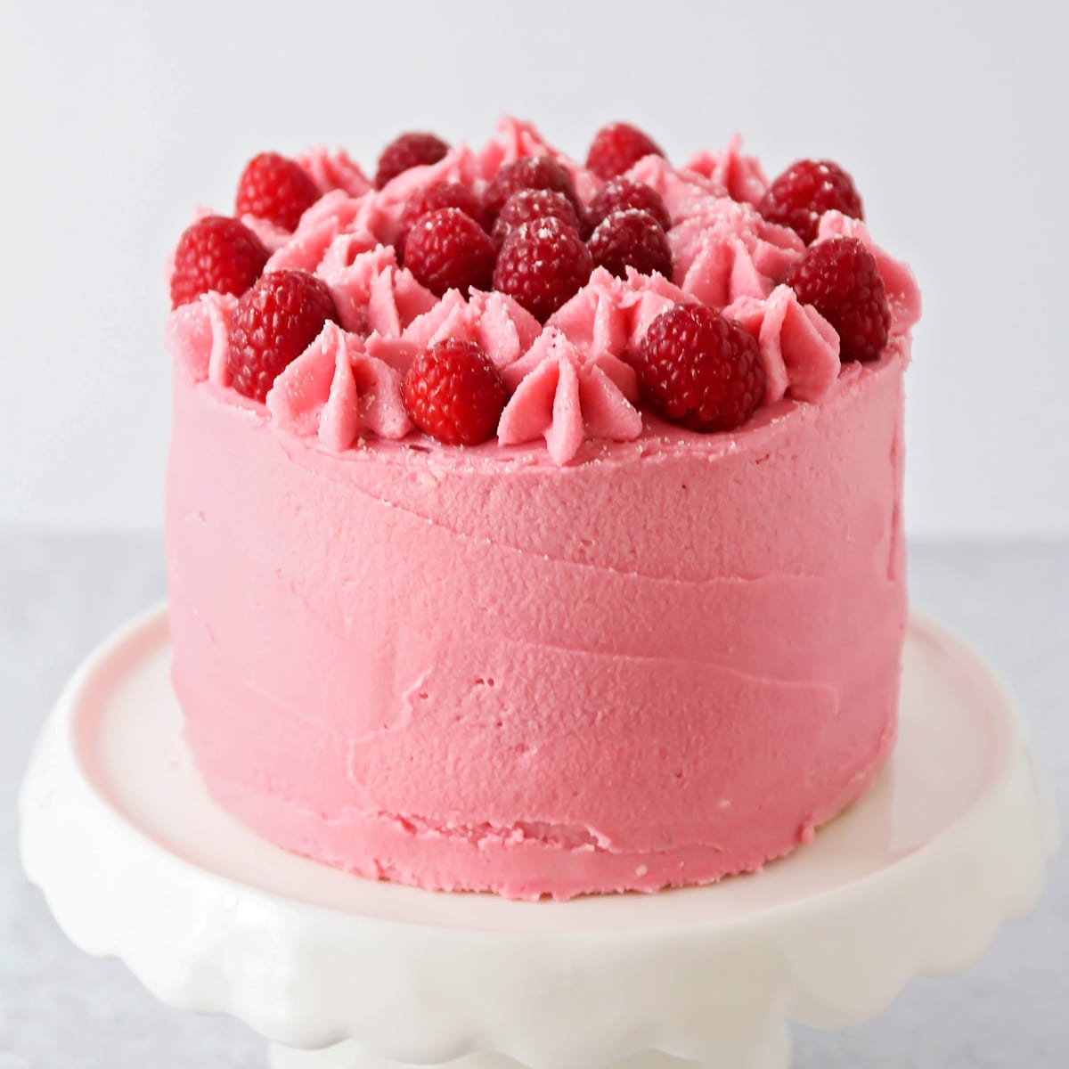 Lemon raspberry cake frosted and topped with fresh berries.