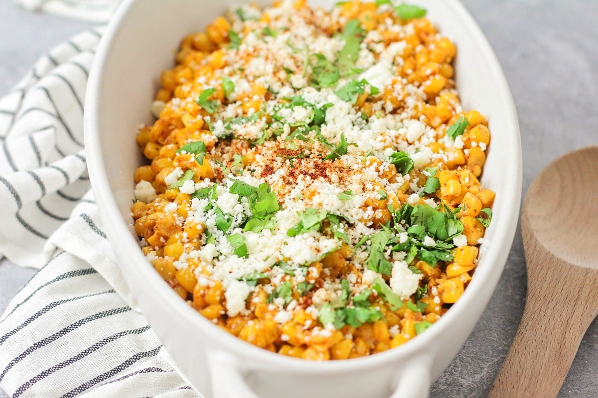 Close up image of Mexican street corn in white bowl.