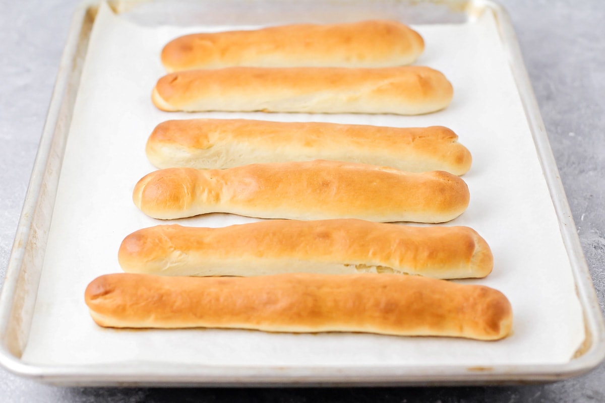 Golden brown breadsticks on a baking sheet.