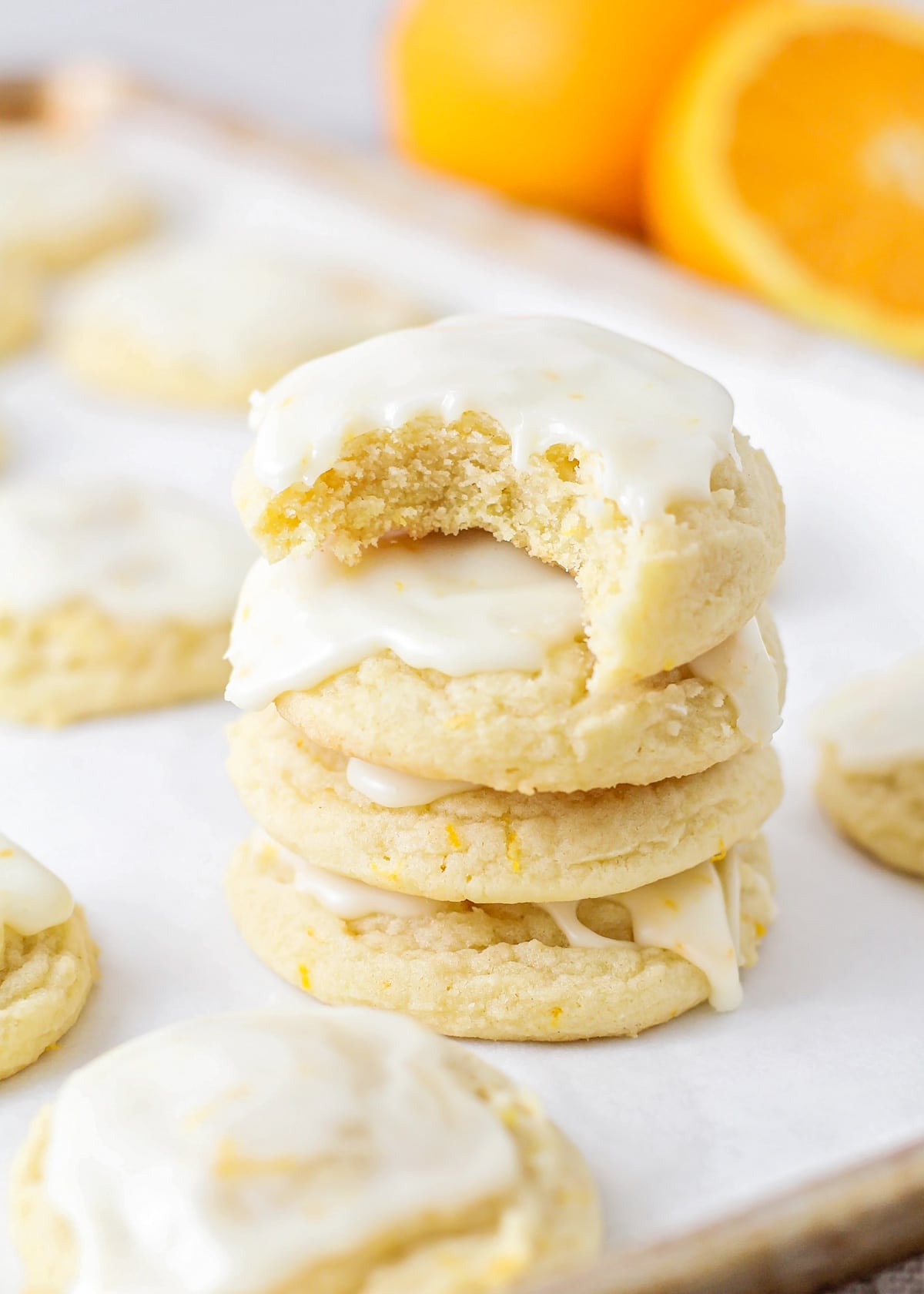 Close up of a stack of orange cookies with a bite taken from the top cookie.