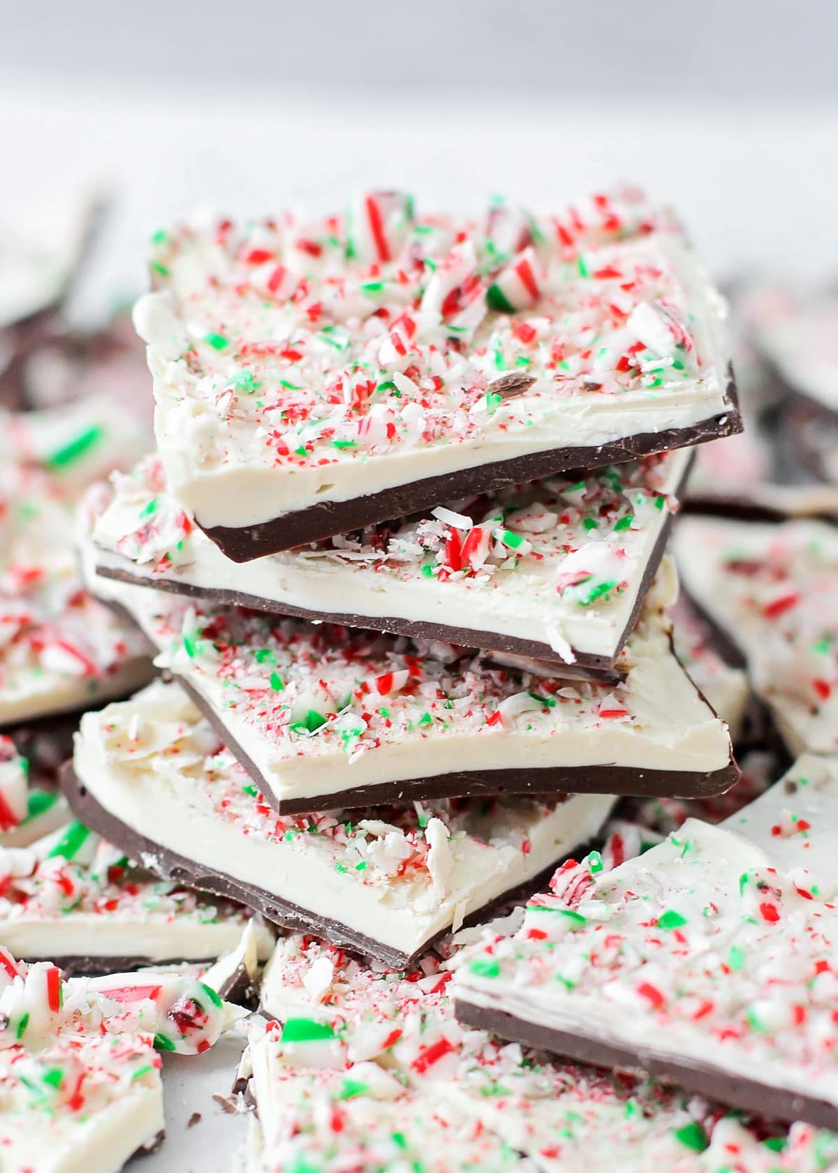Close up of a stack of peppermint bark recipe topped with crushed candy canes.