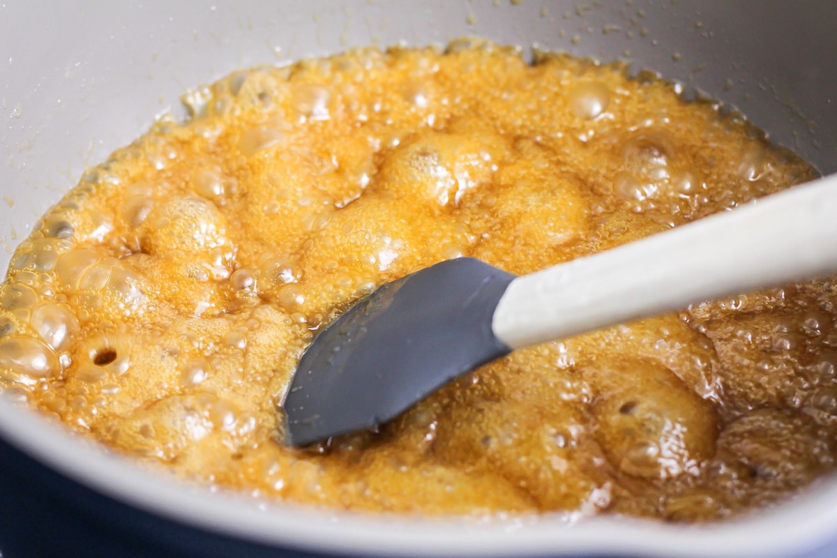 Boiling sugar in a pot to make caramel.