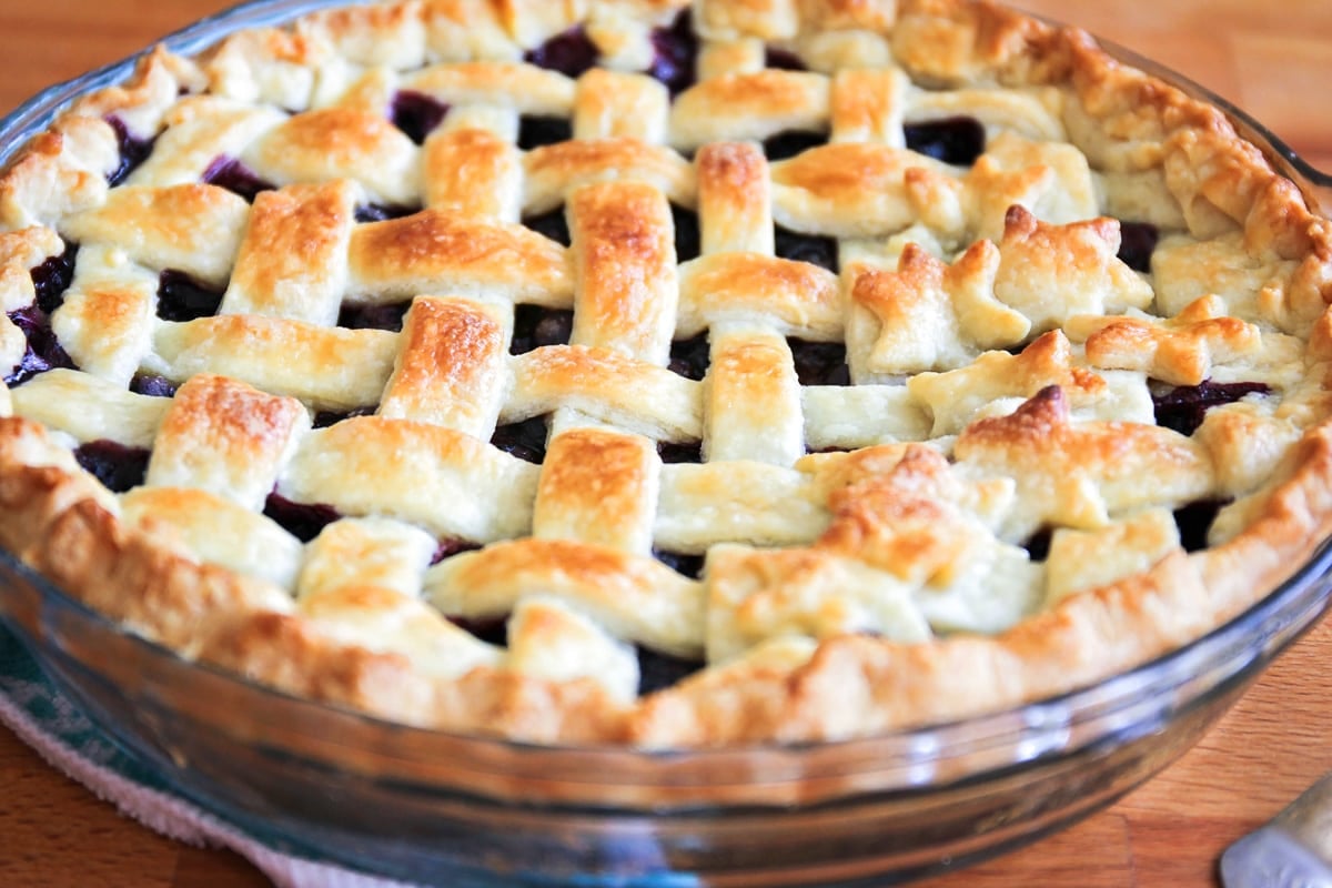 A lattice pie crust with blueberry filling.
