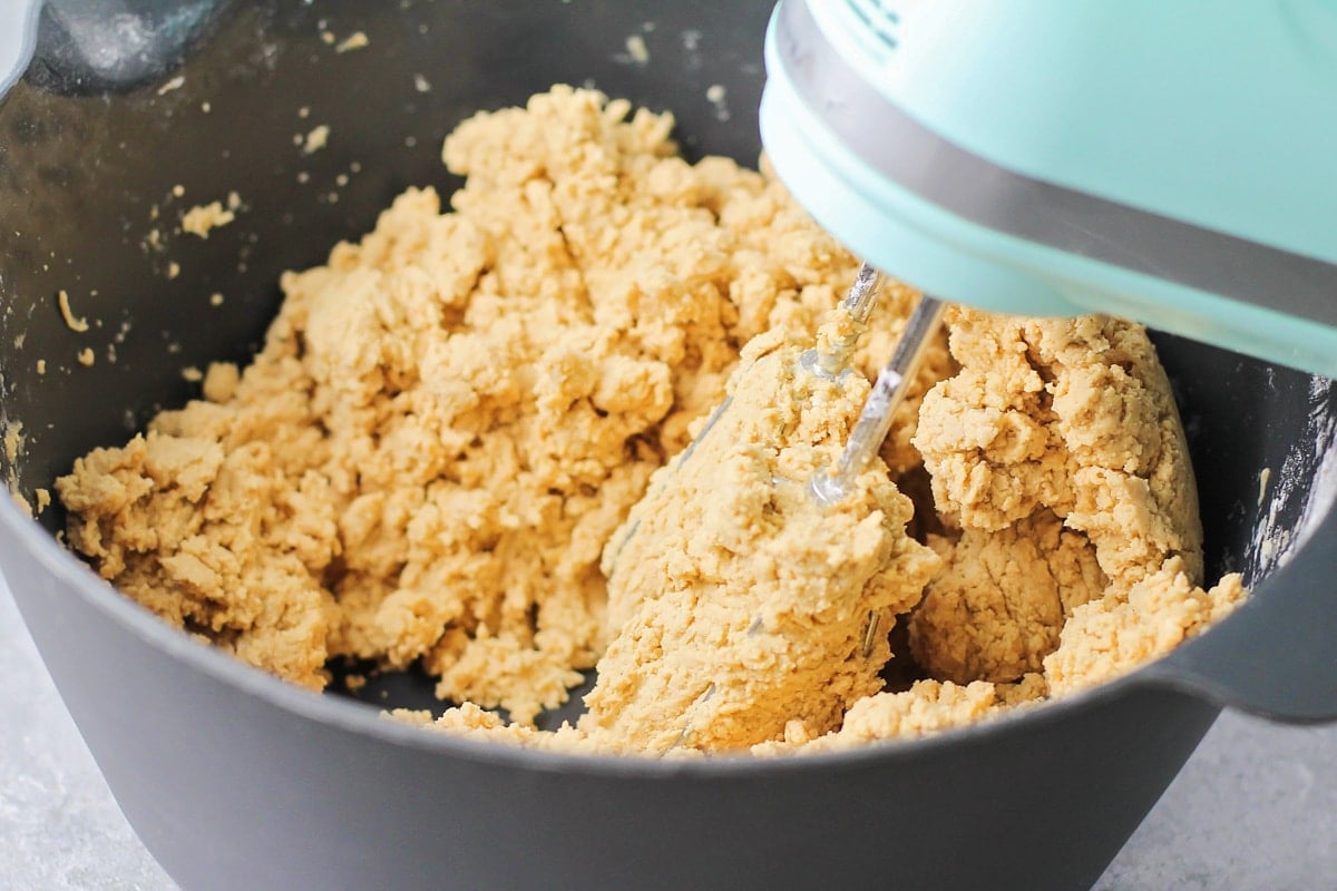 Mixing peanut butter and other ingredients in a grey mixing bowl.