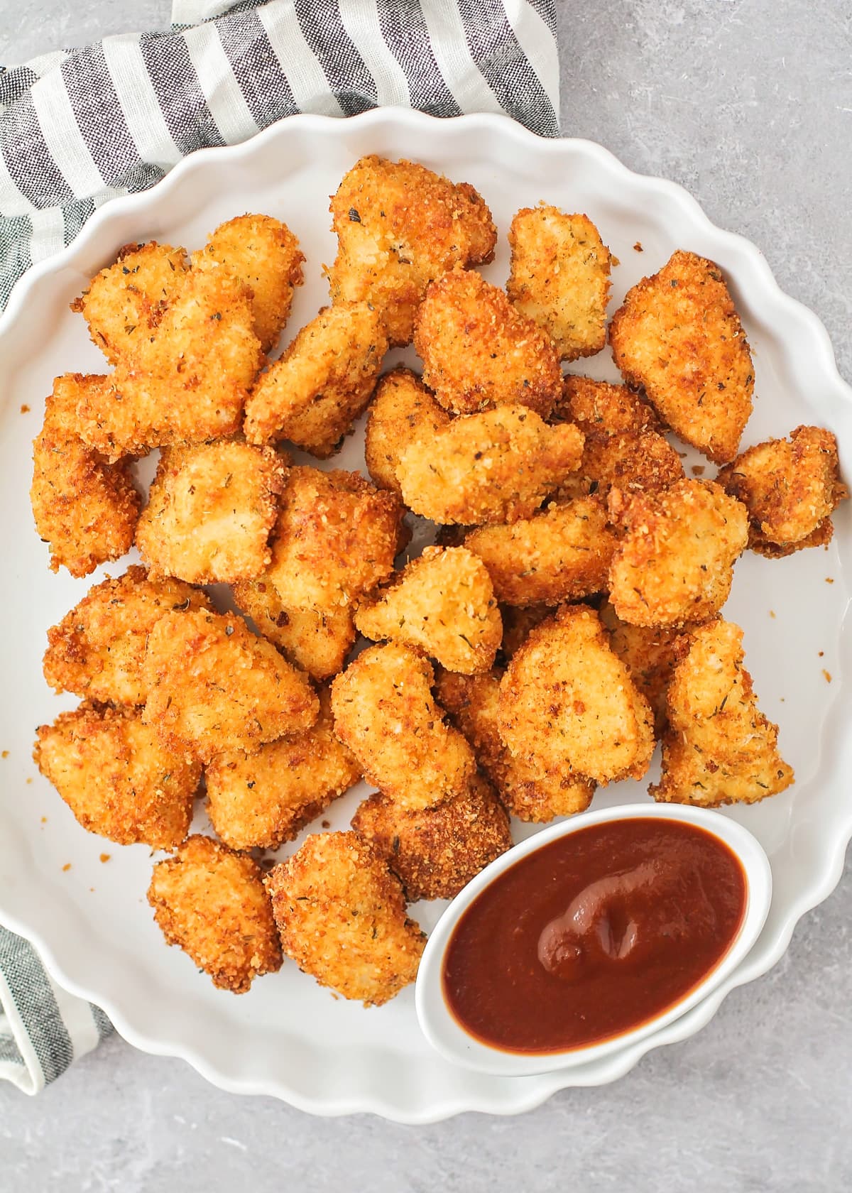 Homemade chicken nuggets recipe on plate with sauce.