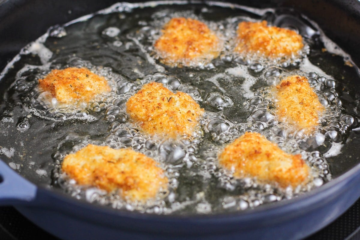 Chicken nuggets frying in oil.