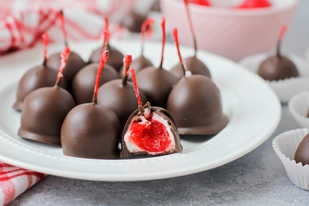 Chocolate covered cherries with one cut in half.