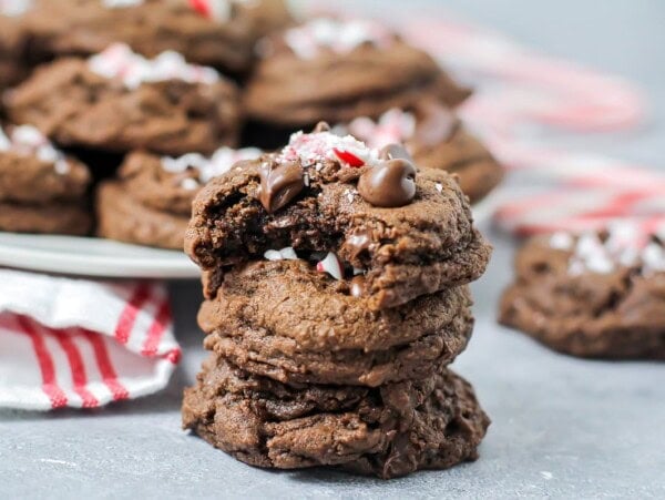 Stacked chocolate peppermint cookies with one bite missing.